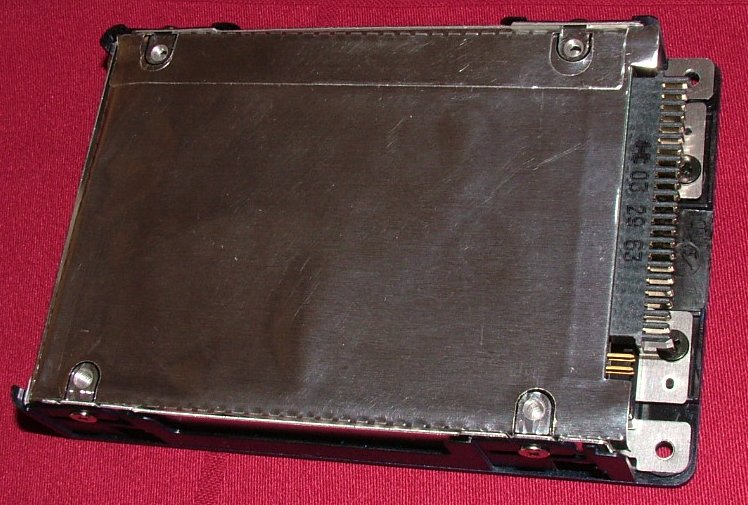 Old drive in its shield and mounting bracket